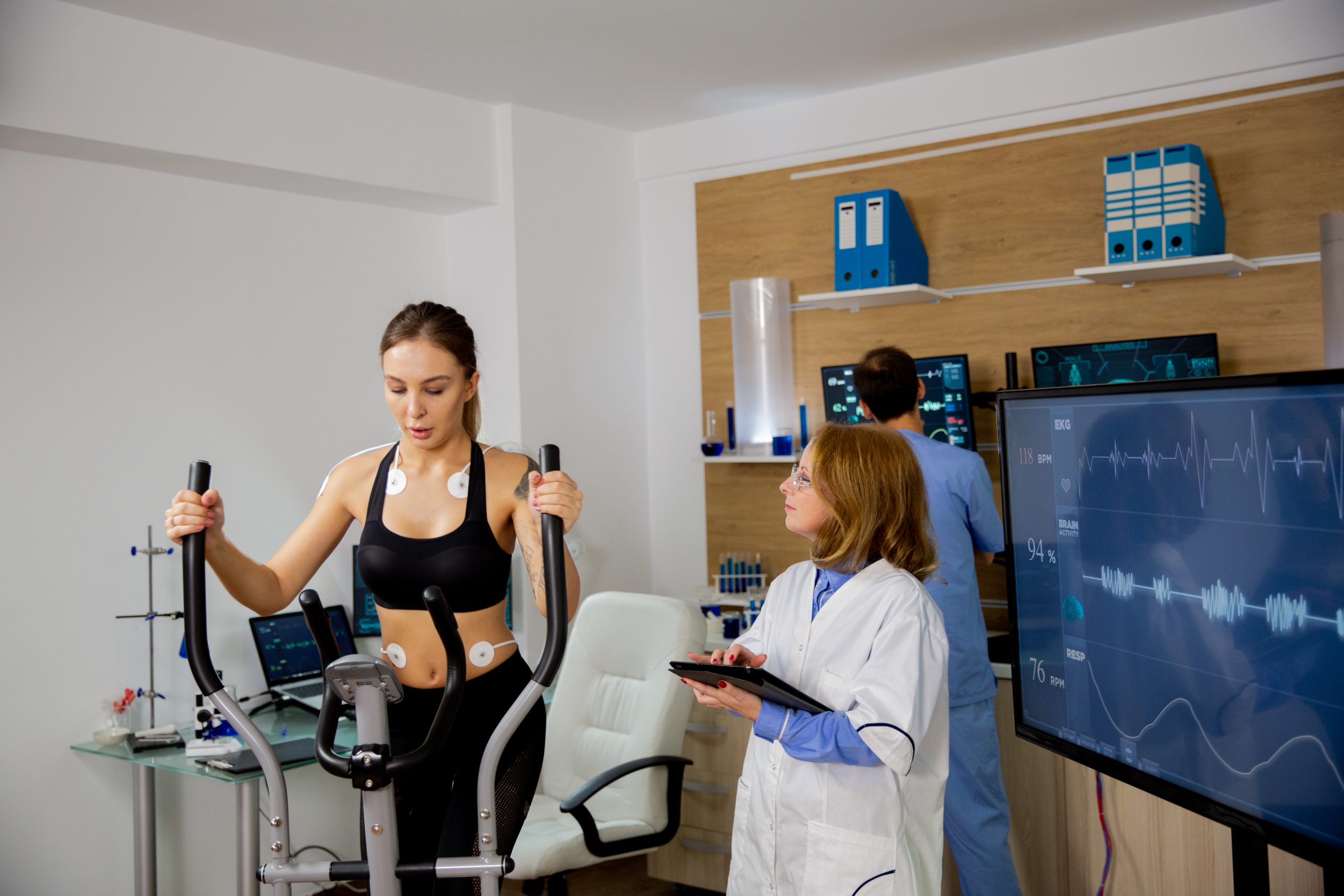 Female athlete doing physical effort on the stepper and the doctor follows her